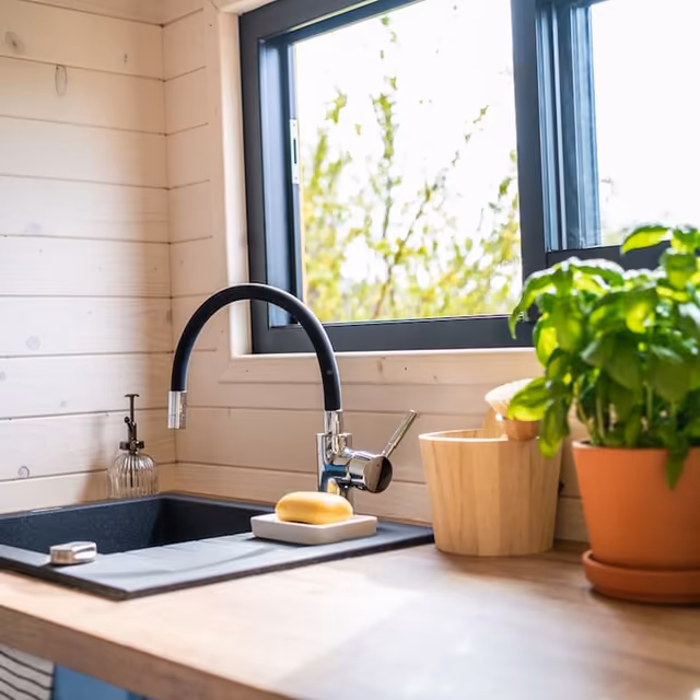 Cuisine de Tiny House avec fenêtre lumineuse et plante verte