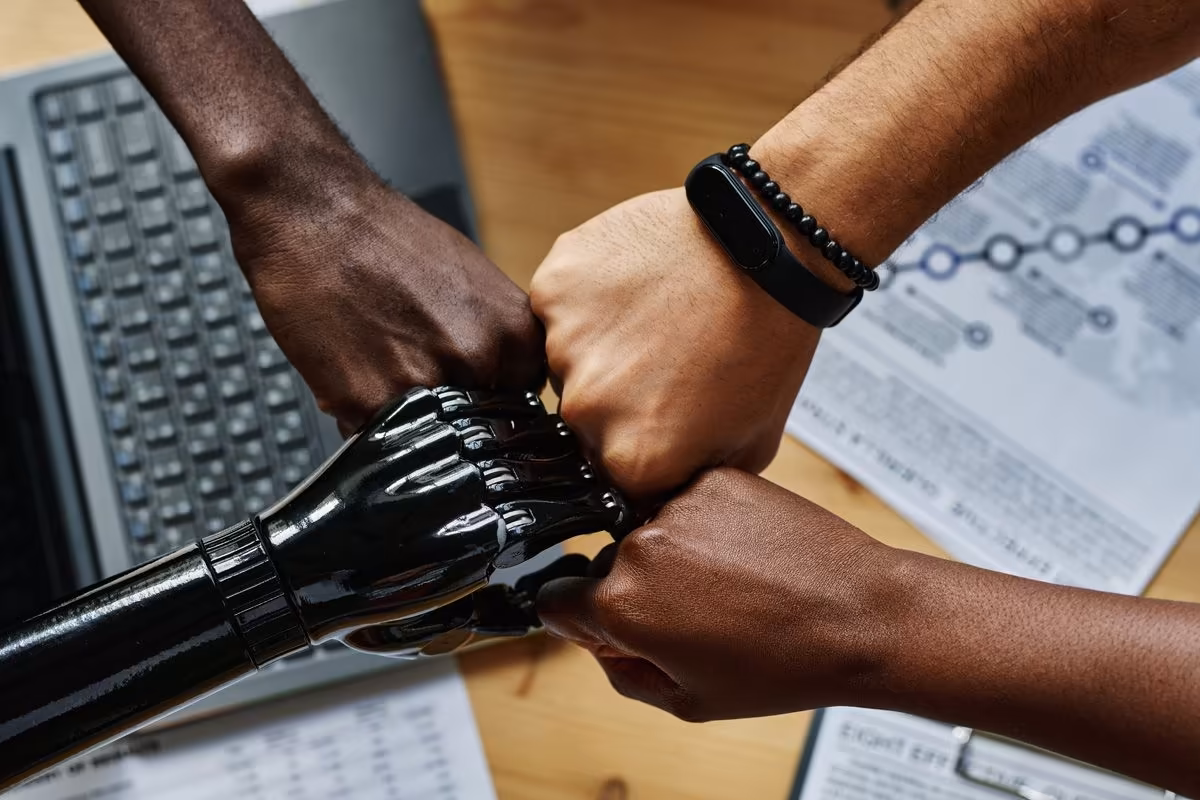 Poings humains et main robot pour une IA encadrée chez Qreative