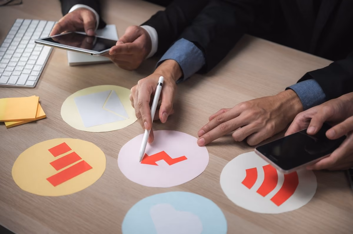 Hands comparing colourful logos, a topic explored by Qreative