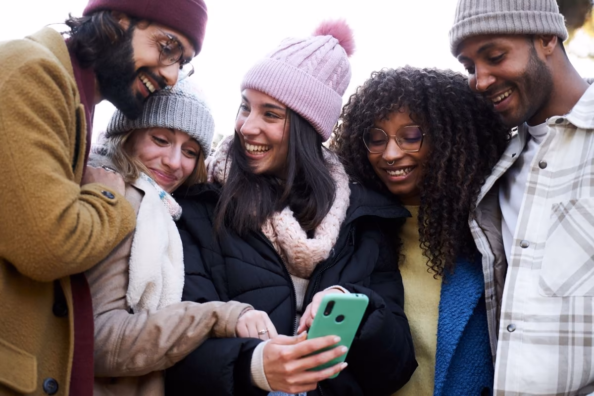 Groupe d’amis captivés par un smartphone dans l’univers Qreative