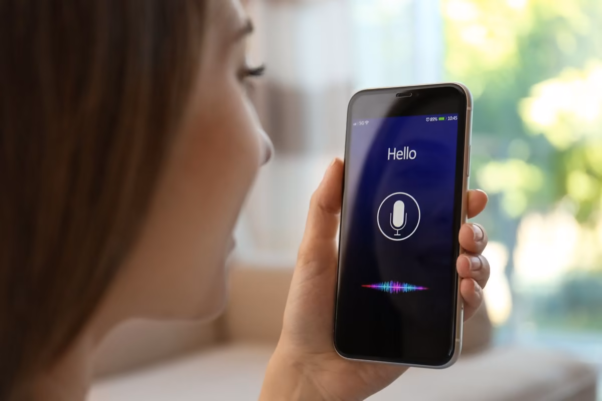 Une femme parle à son smartphone, un usage étudié par Qreative
