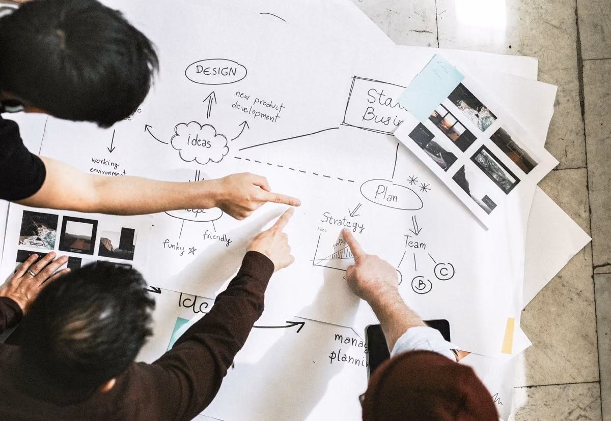 Team reviewing plans and sketches, central to Qreative's approach