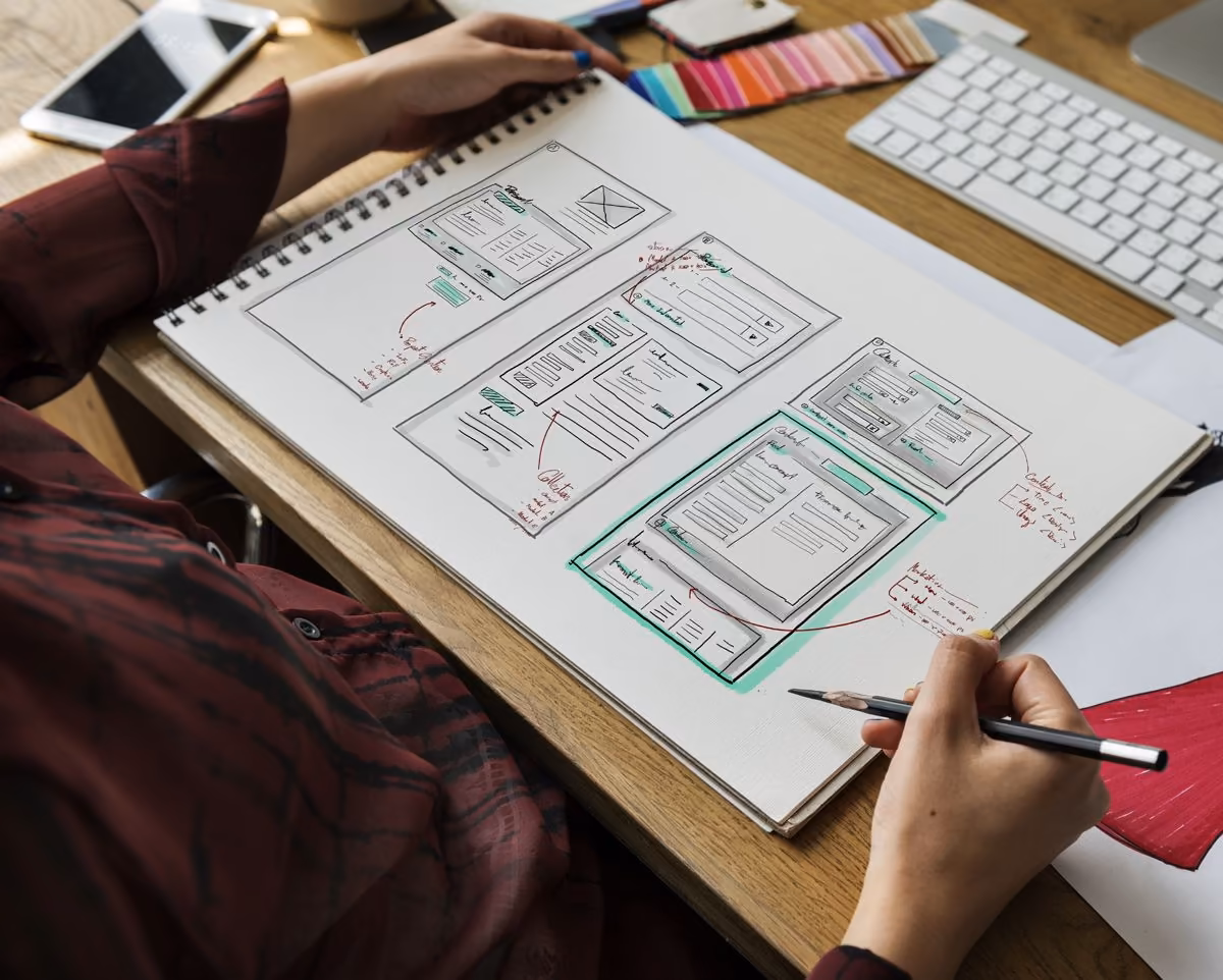 Annotated website wireframes in a notebook: Qreative on UX